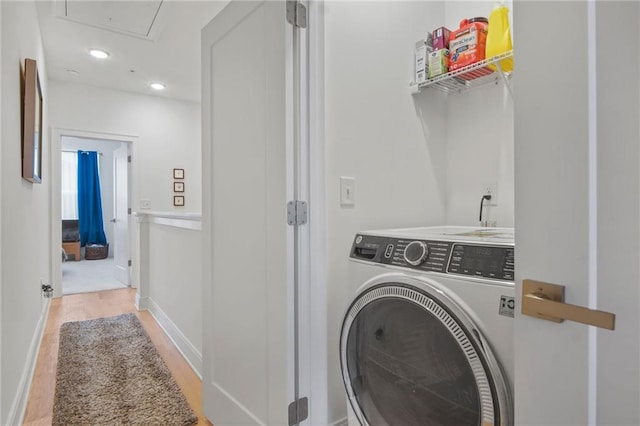 laundry area featuring washer / clothes dryer and light hardwood / wood-style flooring