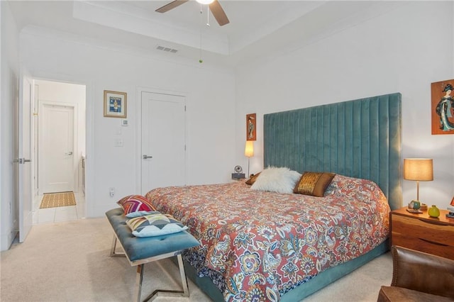 carpeted bedroom featuring ceiling fan and a raised ceiling