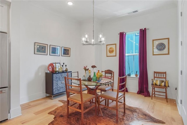 dining space featuring light hardwood / wood-style flooring and a chandelier