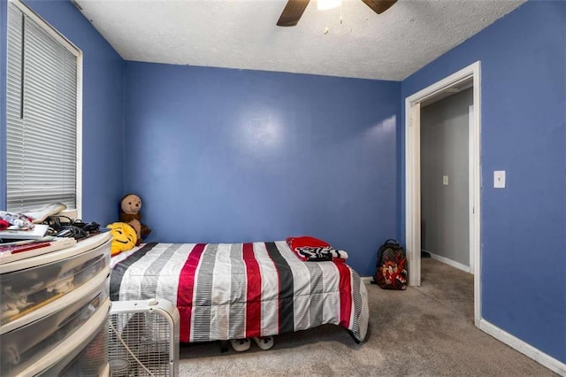 bedroom with carpet flooring, a textured ceiling, baseboards, and a ceiling fan