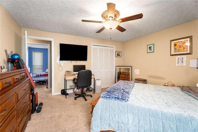 bedroom with baseboards, ceiling fan, light carpet, a closet, and a textured ceiling