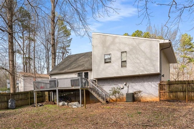 back of property with a wooden deck, stairway, central AC, and fence