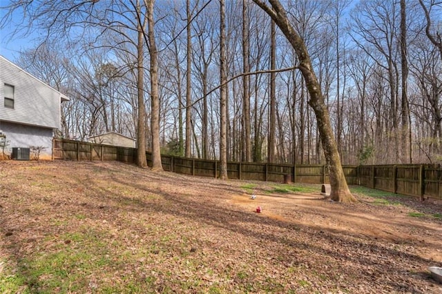 view of yard with central air condition unit and a fenced backyard