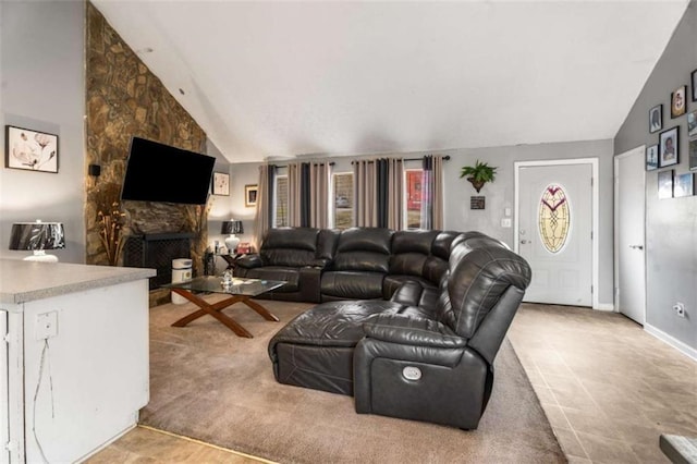 living room featuring a healthy amount of sunlight, a fireplace, and high vaulted ceiling