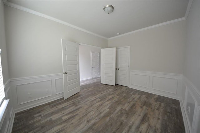 unfurnished bedroom with a closet, a wainscoted wall, wood finished floors, and crown molding