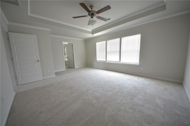 spare room featuring baseboards, visible vents, ceiling fan, a raised ceiling, and carpet flooring