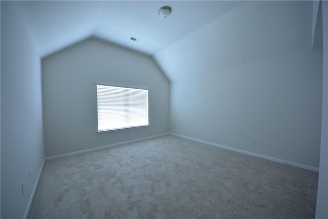 additional living space featuring vaulted ceiling, baseboards, visible vents, and carpet floors