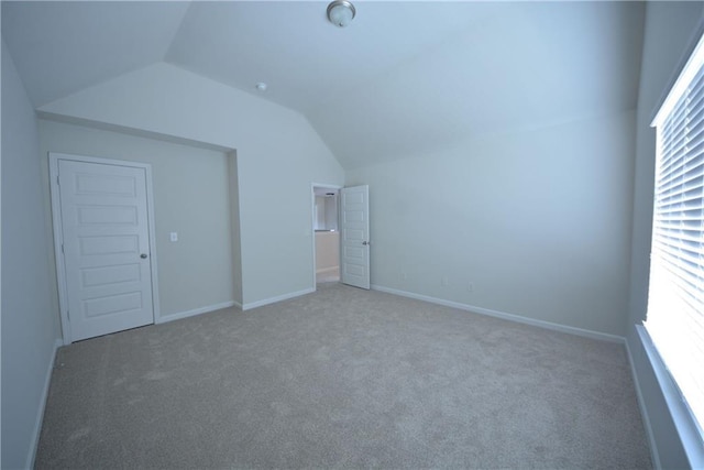 bonus room with baseboards, lofted ceiling, and carpet floors