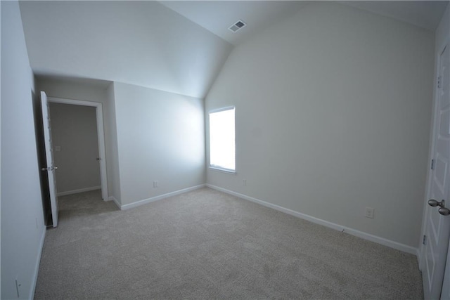 unfurnished bedroom featuring visible vents, baseboards, light colored carpet, and vaulted ceiling