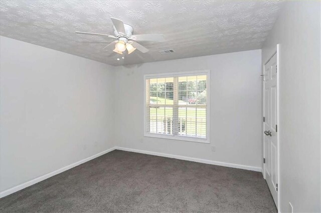 carpeted spare room featuring a textured ceiling and ceiling fan