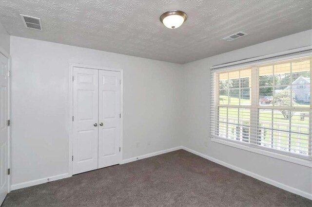 carpeted spare room featuring a textured ceiling