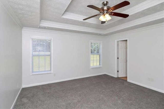 carpeted spare room featuring ceiling fan, a textured ceiling, a raised ceiling, and ornamental molding