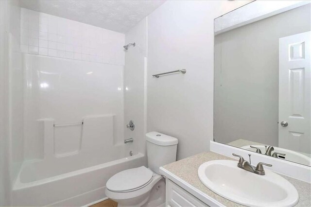 full bathroom with a textured ceiling, bathing tub / shower combination, vanity, and toilet