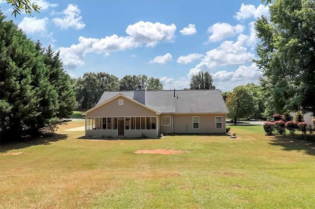 back of property with a sunroom and a lawn