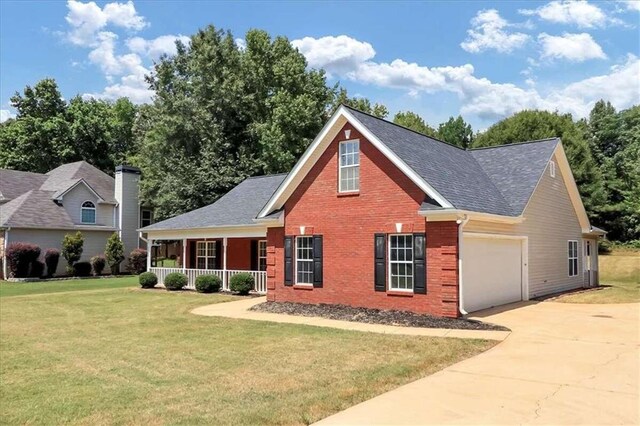 view of front of house featuring a front yard, a porch, and a garage