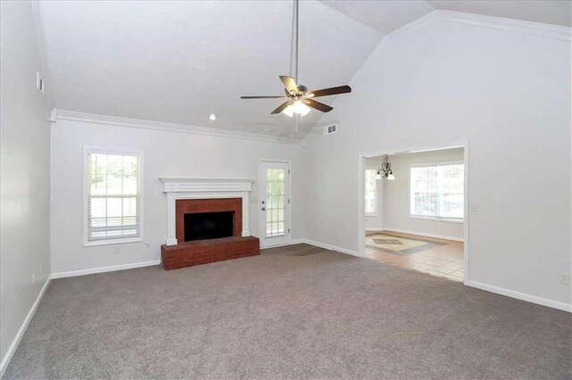 unfurnished living room featuring ceiling fan with notable chandelier, a fireplace, crown molding, and a healthy amount of sunlight