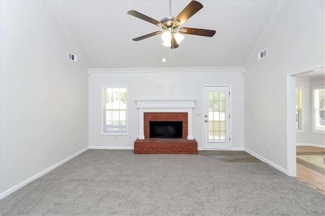 unfurnished living room featuring a brick fireplace, carpet, ceiling fan, and plenty of natural light