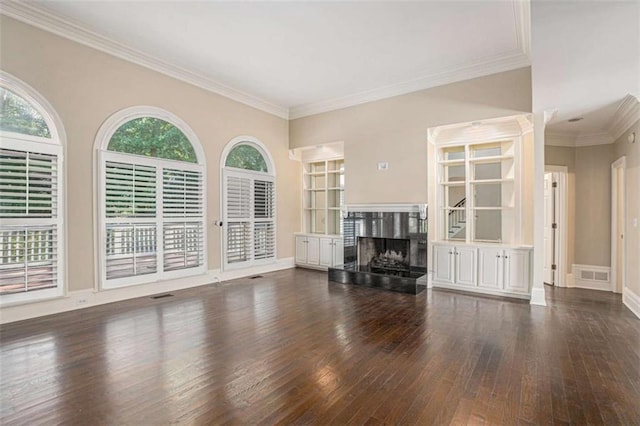 unfurnished living room featuring baseboards, visible vents, hardwood / wood-style flooring, ornamental molding, and a fireplace