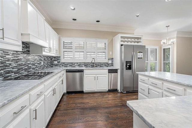 kitchen featuring dark wood-style floors, crown molding, appliances with stainless steel finishes, white cabinetry, and a sink