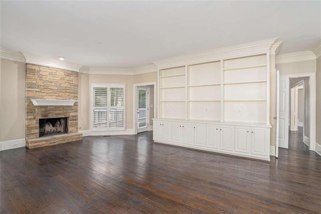 unfurnished living room featuring ornamental molding, dark wood finished floors, a stone fireplace, and baseboards