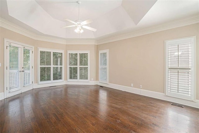 spare room with a ceiling fan, a tray ceiling, baseboards, and wood finished floors