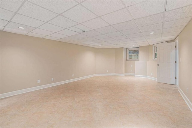 empty room featuring recessed lighting, a drop ceiling, and baseboards