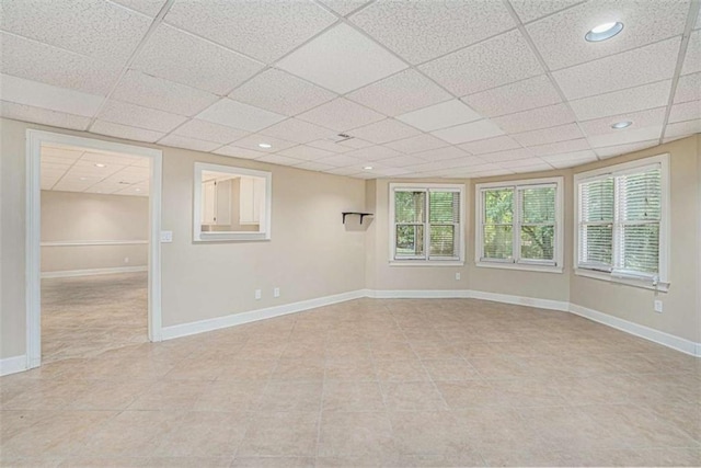 unfurnished room featuring light tile patterned floors, recessed lighting, a paneled ceiling, and baseboards