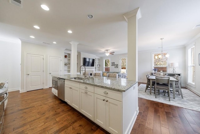 kitchen featuring dark wood-type flooring, sink, ornate columns, appliances with stainless steel finishes, and decorative light fixtures