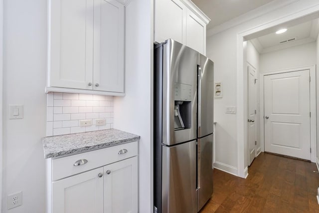 kitchen with light stone counters, ornamental molding, white cabinets, stainless steel fridge with ice dispenser, and dark hardwood / wood-style floors