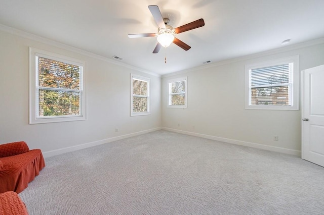 carpeted spare room featuring ceiling fan and ornamental molding