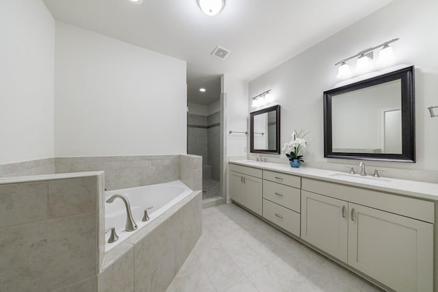 bathroom with tile patterned floors, vanity, and separate shower and tub