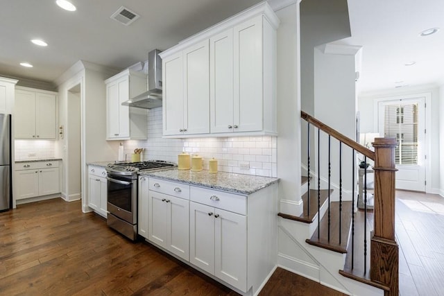 kitchen with dark hardwood / wood-style flooring, white cabinets, and appliances with stainless steel finishes