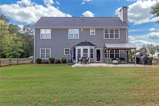 rear view of house featuring a lawn and a patio area