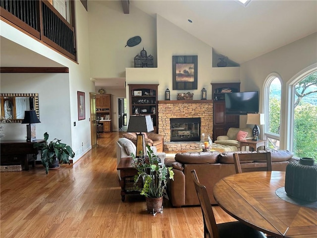 living room with hardwood / wood-style flooring, a fireplace, and high vaulted ceiling