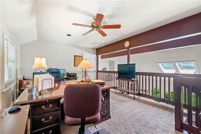 carpeted office space featuring ceiling fan and lofted ceiling with skylight