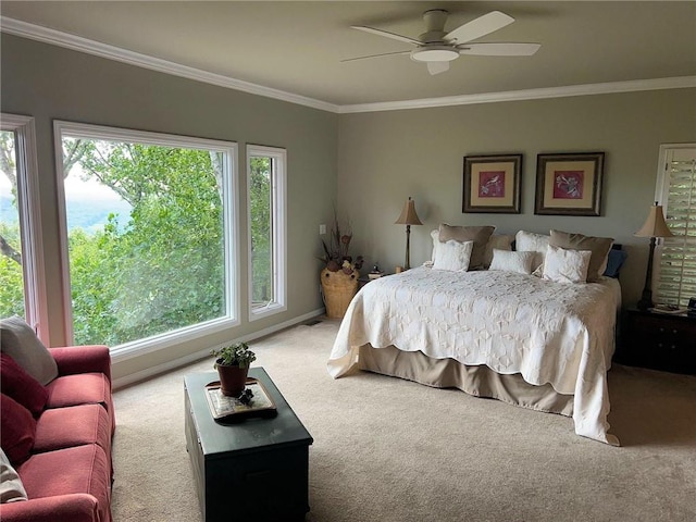 carpeted bedroom with ceiling fan, multiple windows, and ornamental molding