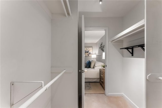 hallway featuring light colored carpet