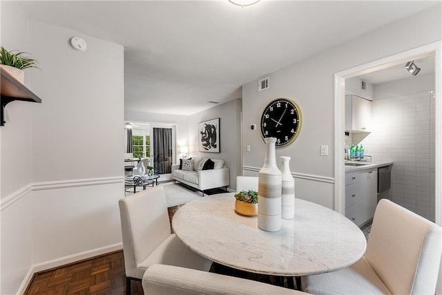 dining room with dark parquet flooring