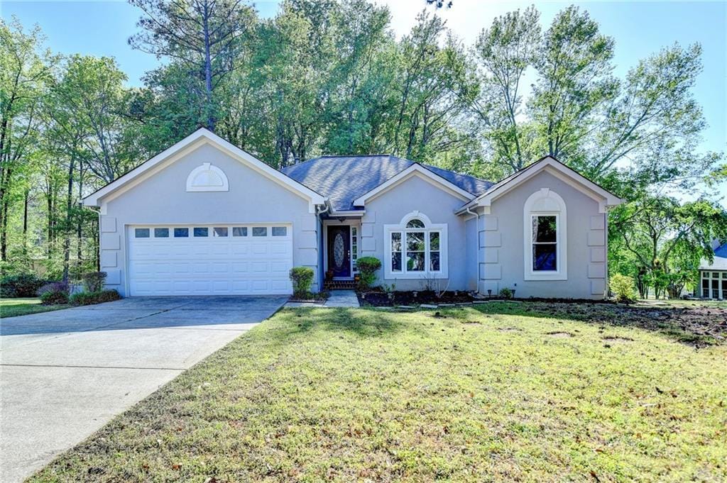 4640 Lambton Cir, Suwanee, GA 30024 - ranch-style house featuring stucco siding, concrete driveway, a front yard, and a garage