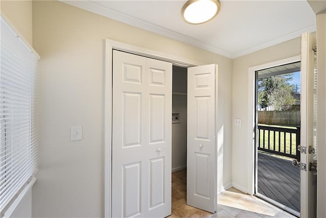 interior space with access to exterior, a closet, ornamental molding, light tile patterned flooring, and baseboards