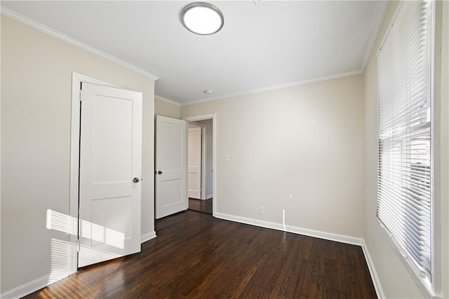 unfurnished bedroom featuring dark wood-style flooring, crown molding, and baseboards