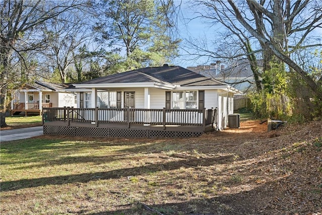 bungalow-style home featuring a chimney, a deck, a front lawn, and central air condition unit