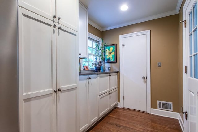 doorway to outside featuring crown molding and dark wood-type flooring