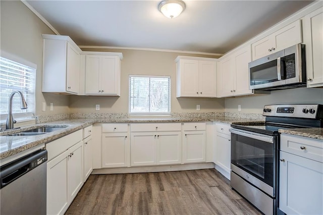 kitchen featuring light stone counters, sink, white cabinets, and appliances with stainless steel finishes