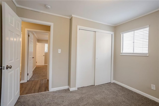 unfurnished bedroom with ornamental molding, carpet flooring, and a closet