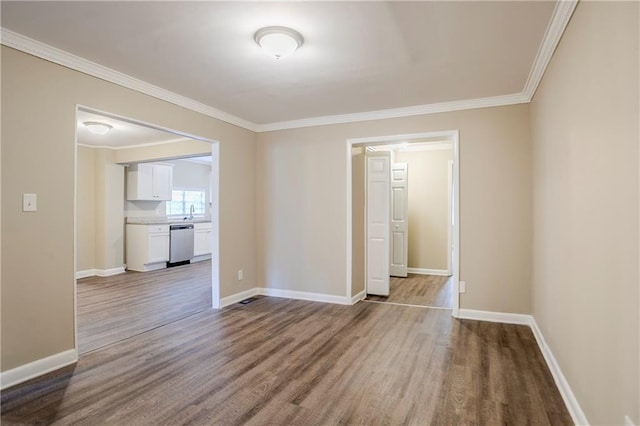 unfurnished room featuring hardwood / wood-style flooring, crown molding, and sink