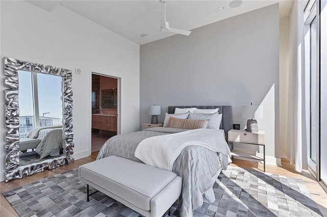 bedroom featuring ensuite bath, baseboards, and wood finished floors