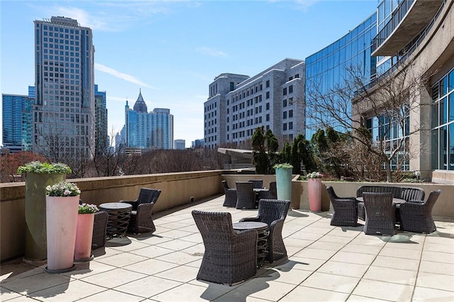 view of patio featuring outdoor dining area and a view of city