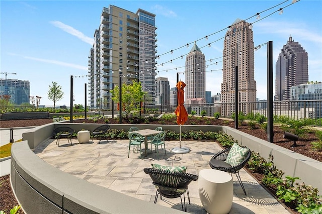 view of patio with a city view and fence