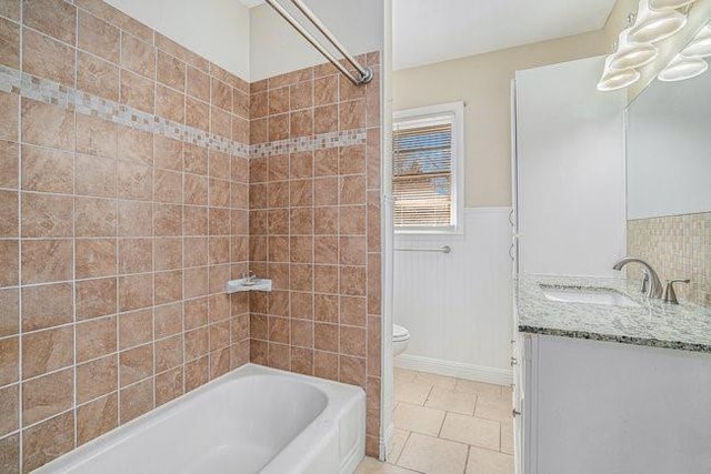 full bathroom featuring tiled shower / bath combo, vanity, tile patterned floors, and toilet